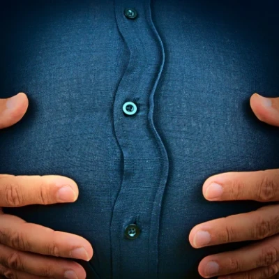 homem com as mãos sobre a barriga estufada.